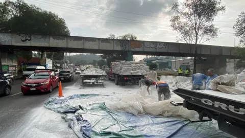 Trabajadores apoyan a la limpieza de bultos de cal sobre la autopista México-Pachuca