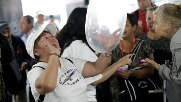 A member of an organization holds an inflated condom during an event organized by AIDS Healthcare Foundation for the International Condom Day, at a metro station in Mexico City