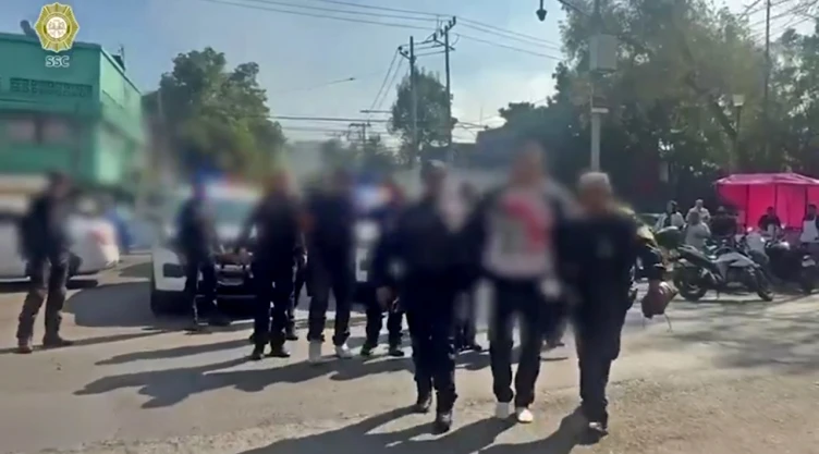 Personas detenidas son escoltadas por policías de la SSC durante un operativo contra extorsión en la alcaldía Cuauhtémoc.