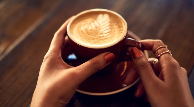 una mujer sostiene una taza de café