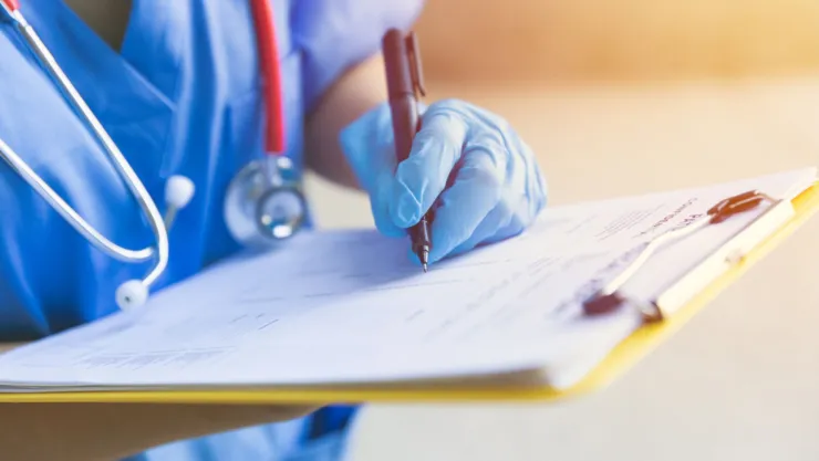 Una médica llena un formulario.