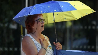 mujer_con_playera_sombrilla_gesto_inhalando_reino_unido
