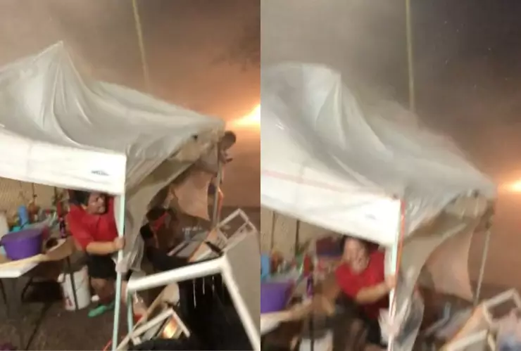 Mujer se aferra a su puesto de elotes durante una fuerte tormenta