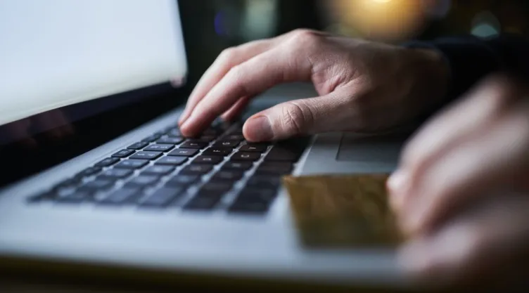 Una persona usa una laptop y una tarjeta.