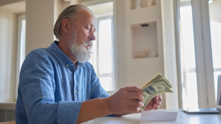 Un hombre cuenta sus ahorros tras su jubilación.