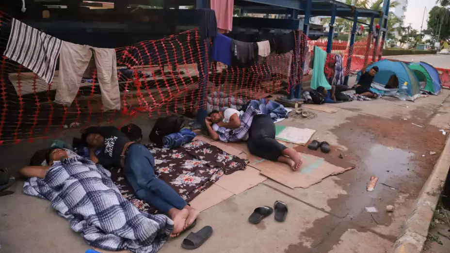 Migrantes durmiendo en un lado de una calle de Acapulco, México.