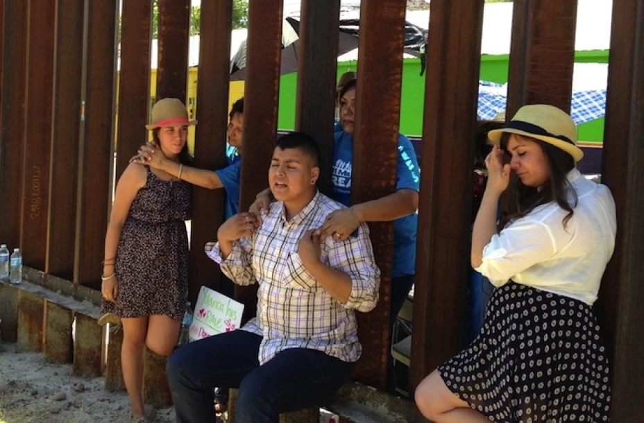 Los dreamers Evelyn Rivera, izquierda, Carlos Padilla, centro adelante, y Renata Teodoro, derecha, se reencuentran con sus madres a ambos lados del muro fronterizo que divide Nogales, Arizona, de Nogales, México