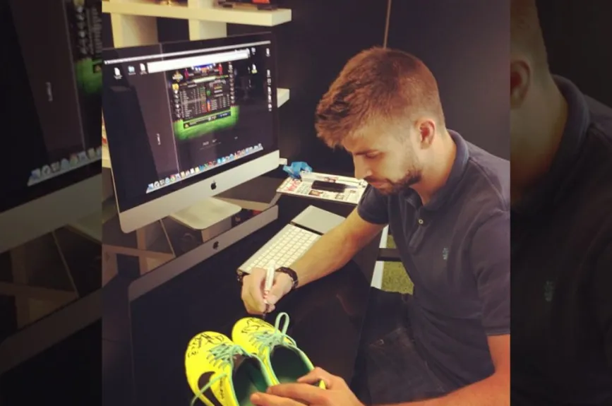 Pique firmando tenis.jpg