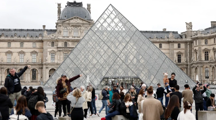 Foto de turistas a las afueras del Museo del Louvre en París, Francia.