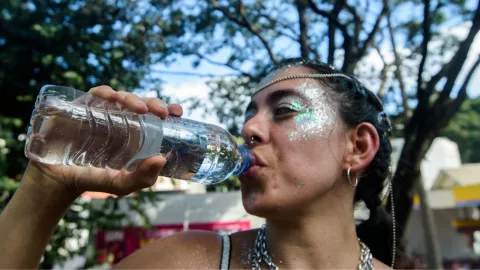 mujer bebiendo agua de una botella embotellada