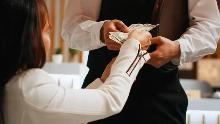 una mujer le deja propina a su mesero que prestó sus servicios