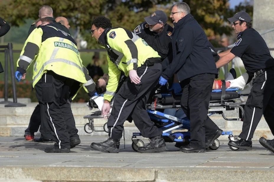 Paramédicos y policías sacan a una víctima del Memorial Nacional de Guerra de Canadá en Ottawa el miércoles, 22 de octubre del 2014. Un soldado que montaba guardia en el memorial fue herido de bala por un pistolero que testigos dicen ingresó posteriormente al edificio del parlamento.