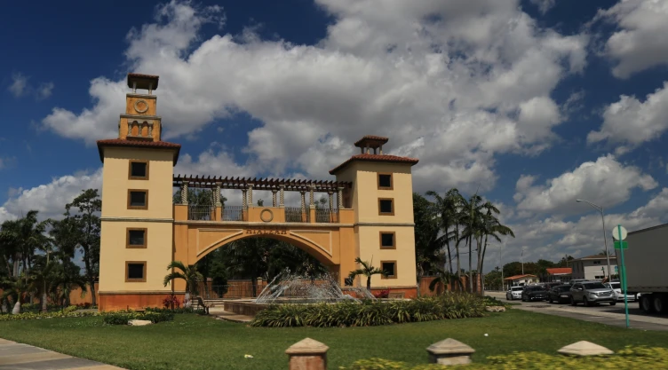 Entrada principal de un pueblo en Florida, con un monumento rodeado de plantas y las calles a los costados