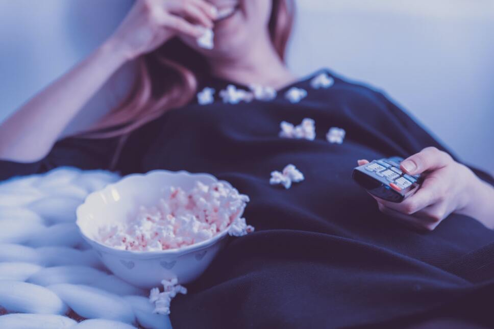 mujer comiendo palomitas y viendo la tv
