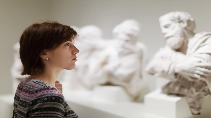  woman looking ancient sculptures  