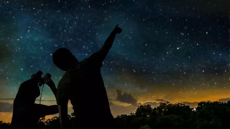 una pareja feliz observa una hermosa noche estrellada 