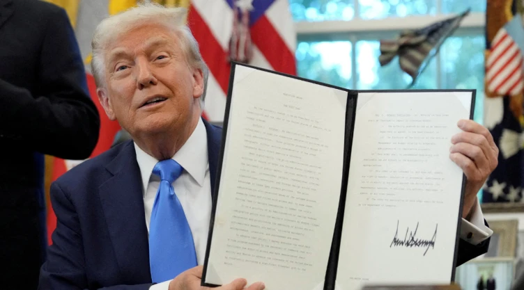 FOTO DE ARCHIVO: El presidente estadounidense Donald Trump muestra una orden ejecutiva firmada sobre la visa de tarjeta dorada en el Despacho Oval de la Casa Blanca en Washington, D.C., EE. UU., el 19 de septiembre de 2025. REUTERS.