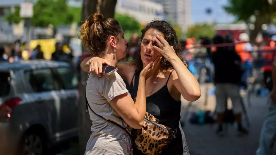 Personas aturdidas por la caída de un misil iraní en Tel Aviv, Israel.