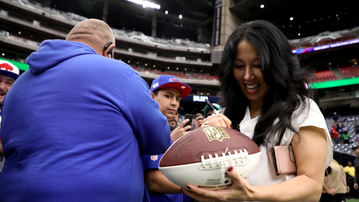 Kim Pegula, dueña de los Buffalo Bills, ofrece un autógrafo a un aficionado