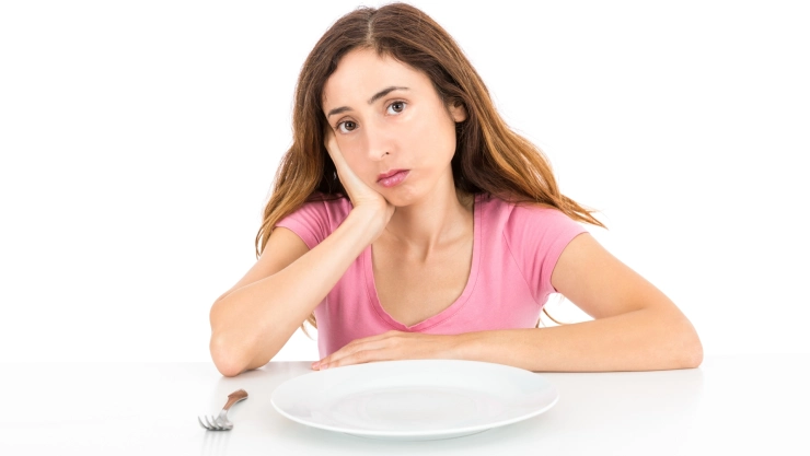 Mujer hambrienta con su plato vacío