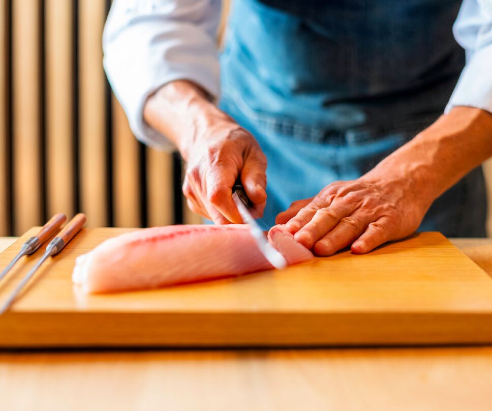 chef cortando pescado para comida japonesa