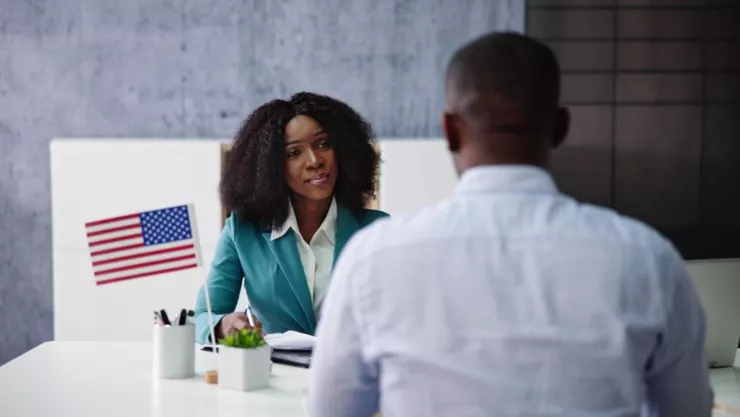 Una persona entrevista a otra como parte de su solicitud de residencia permanente.