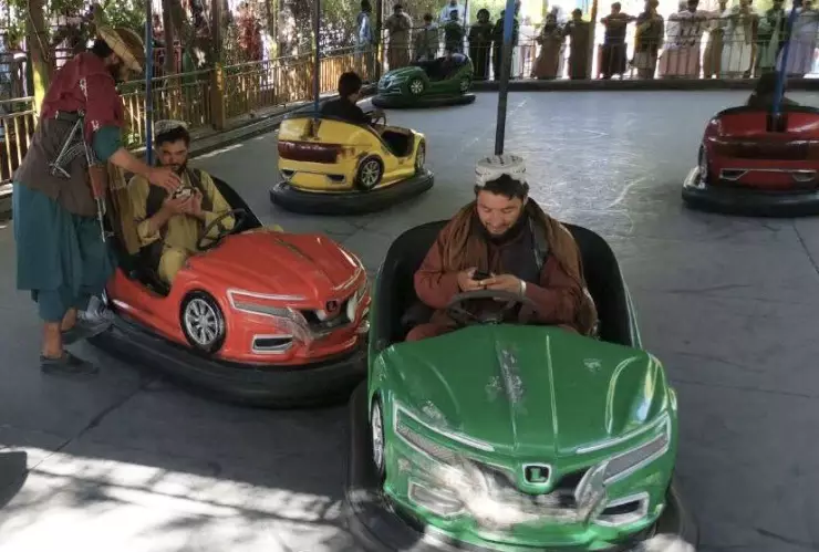 Talibanes se divierten mientras juegan en los carritos chocones en Kabul, Afganistán.