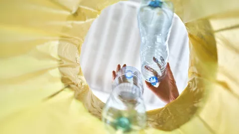 botellas de plástico siendo desechadas en una bolsa de basura