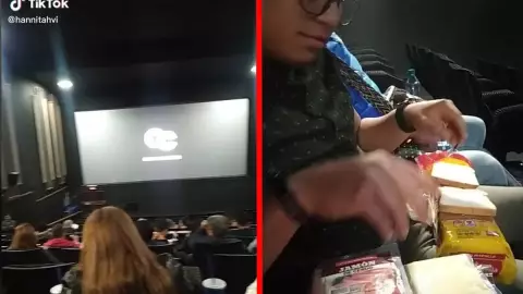 Joven prepara sándwiches en la sala del cine.- 